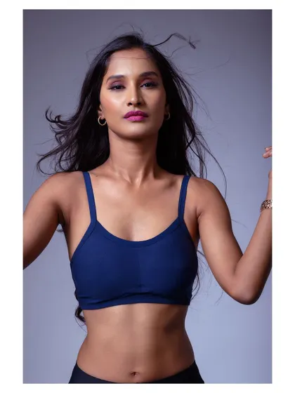 A strong and moody portrait in a sports bra. The lighting sculpts the model's features, creating a powerful and athletic look.
