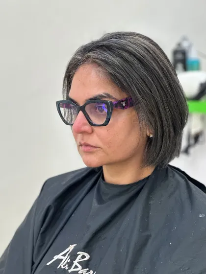 A before-and-after look at a major color correction. We took this client from brassy tones to a sleek, silver-highlighted bob that blends her natural greys beautifully.