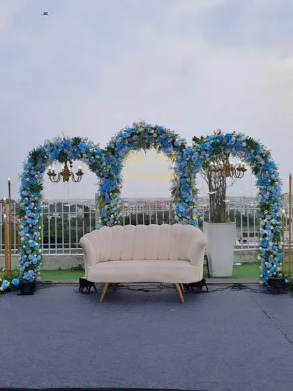 An elegant rooftop floral decoration for a post-wedding party. The blue floral arches against the city skyline create a breathtaking and unique celebration space.
