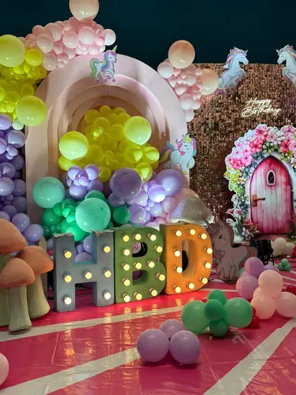 A close-up of the "HBD" marquee letters and mushroom props from the enchanted garden setup.