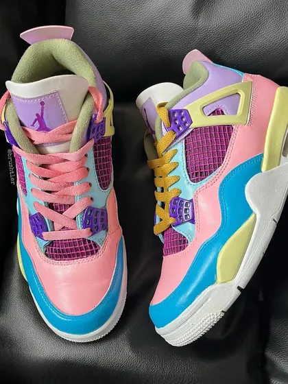A top-down view of the custom pastel Jordan 4s, showing the mismatched laces.