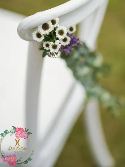 A small posy of daisies and purple flowers adds a delicate touch to the guest seating.