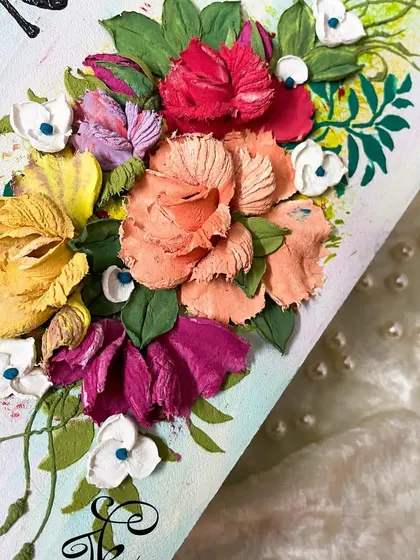 A close-up of the flower arrangement on a nameboard. I love mixing different flower types and colors, like the peachy tones and bright pinks here, to create a balanced and eye-catching composition.