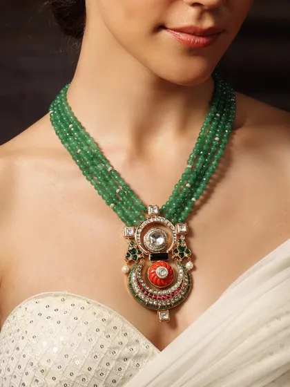 A unique piece from our Emrosia collection, this necklace features a central pendant with a deity motif on a string of green beads.