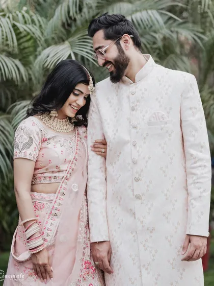 A quiet, candid moment between the couple, showcasing their beautiful pastel outfits and the easy comfort they share.