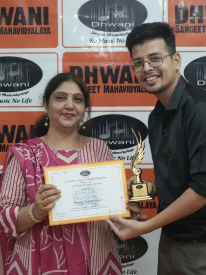 A teacher presents an award to his adult student.