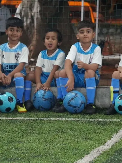 Our toddler batch players sitting on the sidelines with their footballs, taking a quick break.