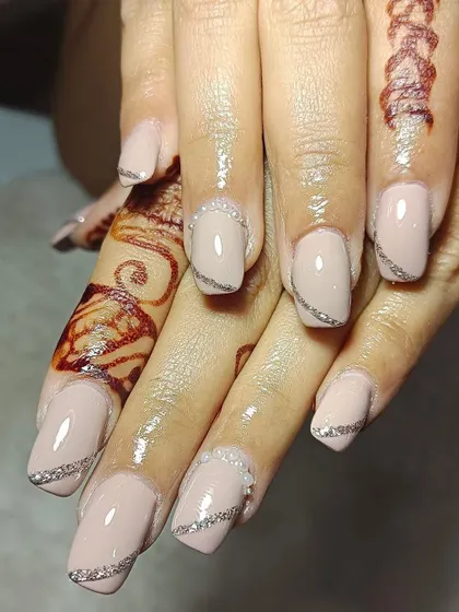 For these nude bridal nails, I added delicate silver glitter lines and tiny pearl details. This design looks so classy and perfectly complements the client's mehendi.