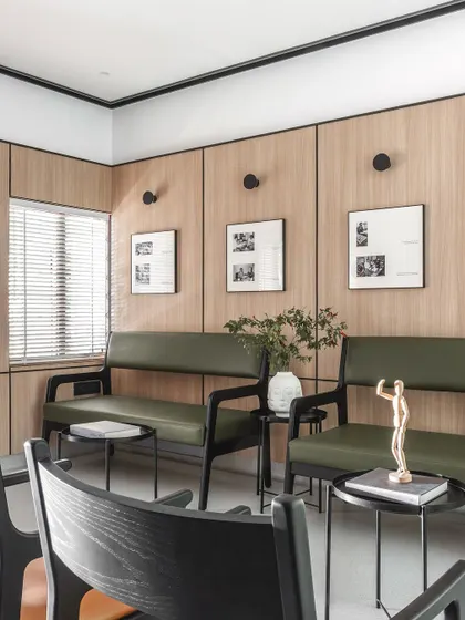 The waiting area features comfortable seating and is decorated with historical photos of the clinic's lineage. This detail connects the modern space to its rich, four-generation history.