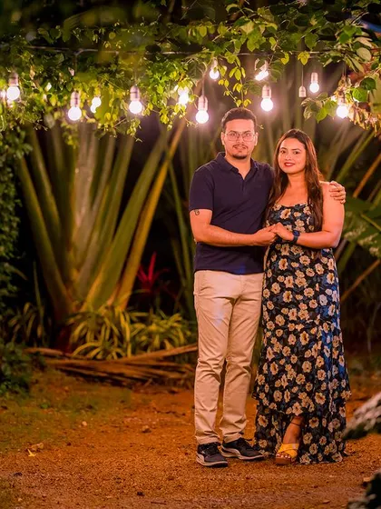 A classic portrait under a canopy of hanging lights. The warm glow and natural surroundings create a perfect setting for a romantic and timeless photo.