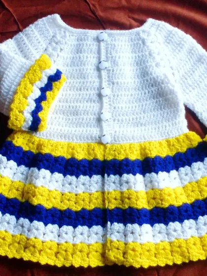 A bright and cheerful baby frock with bold blue, yellow, and white stripes. This handmade cardigan is perfect for adding a splash of color to any outfit.