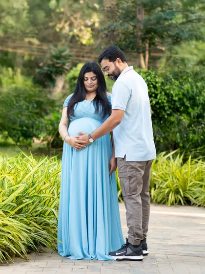 A gentle and loving pose between partners during their outdoor pregnancy photoshoot. The focus is on their connection and the beautiful baby bump.