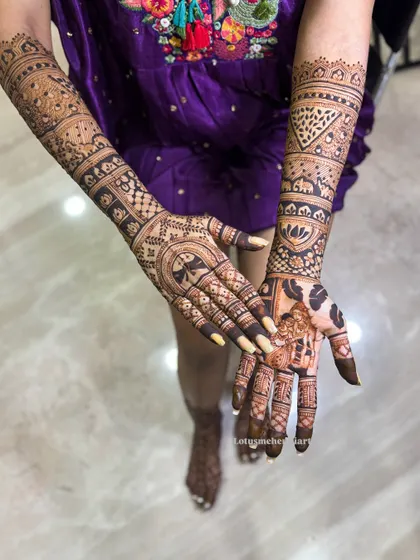 The back of Harshitha's hands, featuring a unique design that combines geometric patterns with traditional symbols, creating a cohesive and stunning bridal look.