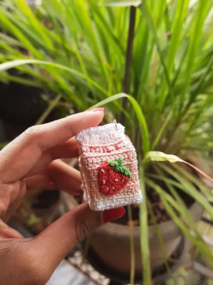 Another shot of the strawberry milk amigurumi. It's a sweet and nostalgic design that makes a perfect accessory.