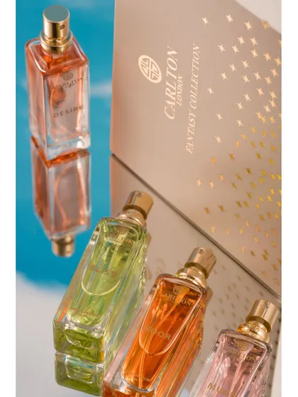 A creative composition using mirrors to reflect perfume bottles against a sky-blue background. The reflections add depth and an ethereal quality to the shot, making the products feel dreamy and aspirational.