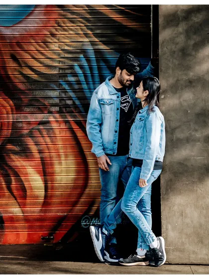 A stylish urban pre-wedding shot, with the couple posing against a colorful graffiti wall, adding an edgy and modern feel.