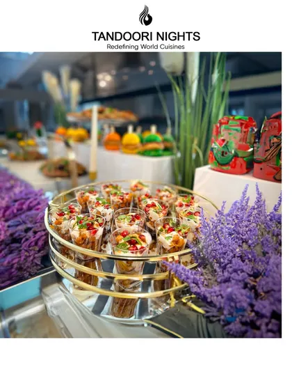 A beautiful display of appetizers in shot glasses, garnished with pomegranate seeds and set amidst lavender, showcasing our commitment to creating an unforgettable experience.
