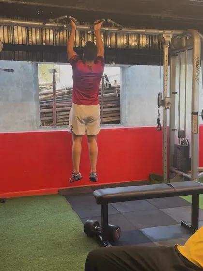 A client performs a pull-up, a challenging bodyweight exercise that builds upper body and back strength. We help clients progress towards mastering this movement.
