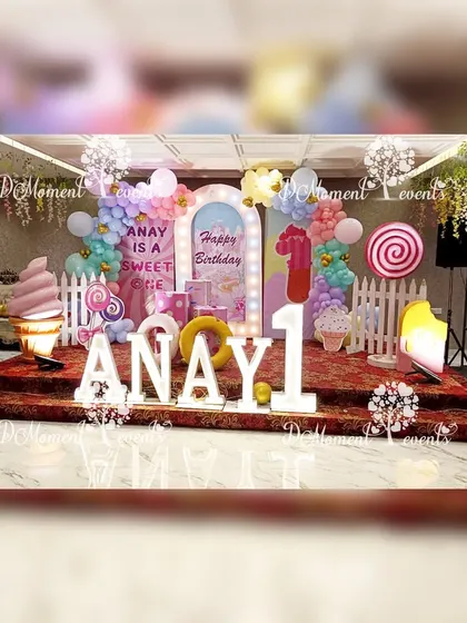 A full view of the whimsical Candyland stage, complete with hanging decorations and fun, oversized sweet treat props.