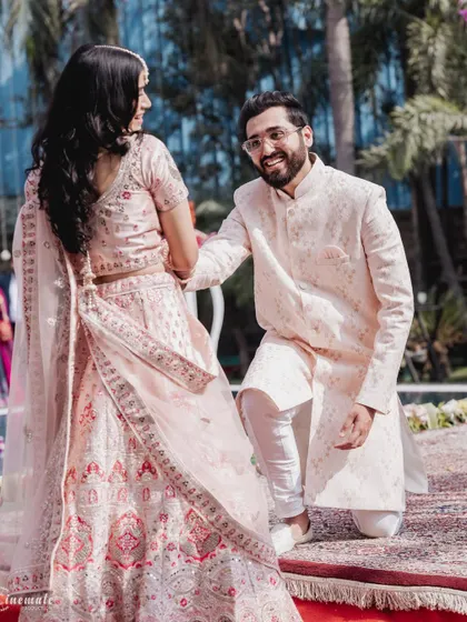 A playful and romantic moment during the pre-wedding festivities. The groom's kneeling pose adds a touch of classic romance.