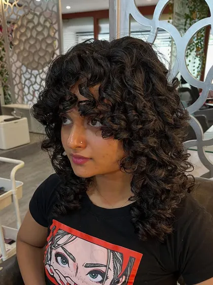 The curly shag with bangs frames the face beautifully.