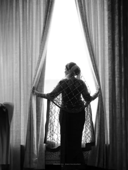 An artistic silhouette of the bride looking out the window, a powerful and evocative black and white image.