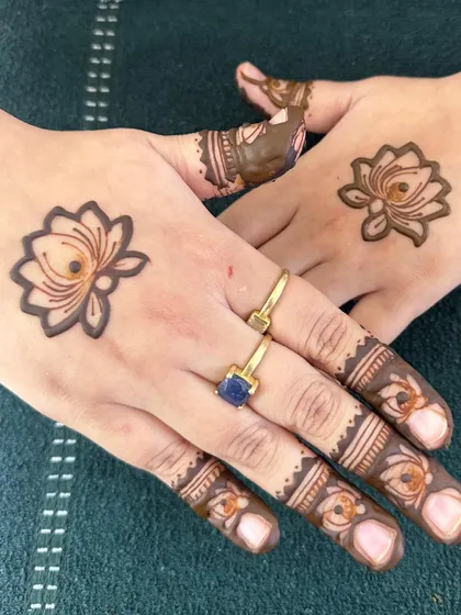 The minimal game is going strong with this simple lotus motif on the back of the hand.