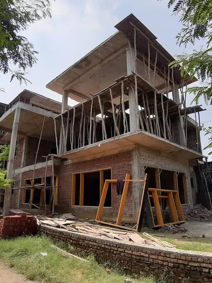 Building up. An exterior view of a residence under construction, with the structural frame and brickwork complete.