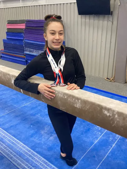 Our Level 9 gymnast, Addy, with her medals after qualifying for the Regional meet.