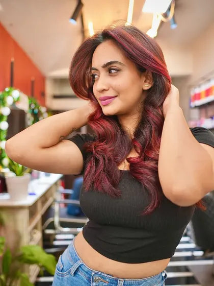 Here's a beautiful shot of a client enjoying her new vivid red hair. The color is rich and dimensional, styled with soft waves to catch the light perfectly.