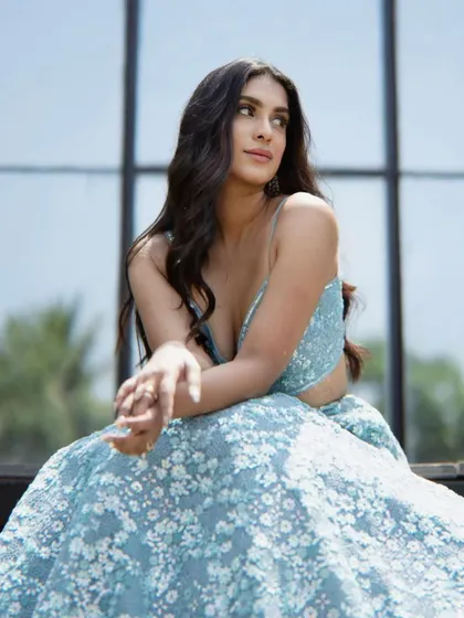 An elegant and regal look. The soft, smokey eye and loose waves create a timeless beauty look that perfectly complements this pastel blue lehenga.