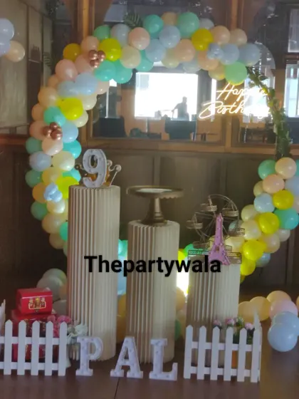 A pastel-colored balloon ring with a 'Happy Birthday' banner, perfect for a daytime party.