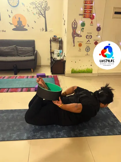 A client uses a yoga wheel for a supported Dhanurasana (Bow Pose). This prop aids in achieving a deeper backbend and chest opening, enhancing the benefits of the posture.