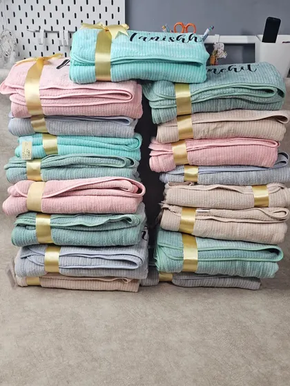 Stacks of our customized towels, ready to be gifted. Available in a variety of pastel colors, they are a practical and elegant gift for any occasion.