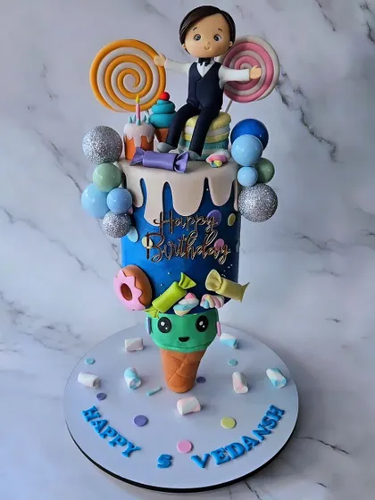 A full view of the gravity-defying ice cream cone cake. It's a whimsical showstopper, combining the fun of a candyland theme with a complex, surprising structure.