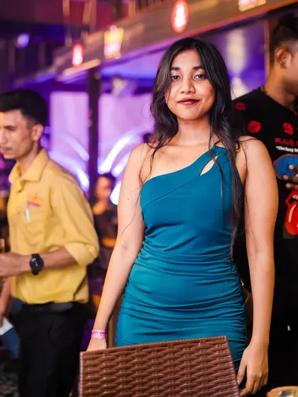 A guest posing for a photo, showcasing her party outfit.