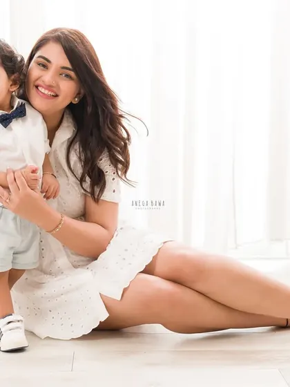 A relaxed and happy portrait of a mother and son sitting on the floor. Their genuine smiles and easy connection shine through.
