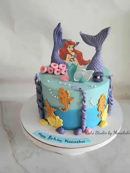 A magical mermaid-themed cake with an underwater scene. This design features Ariel, seahorses, and purple mermaid tails, creating a fun and vibrant look.