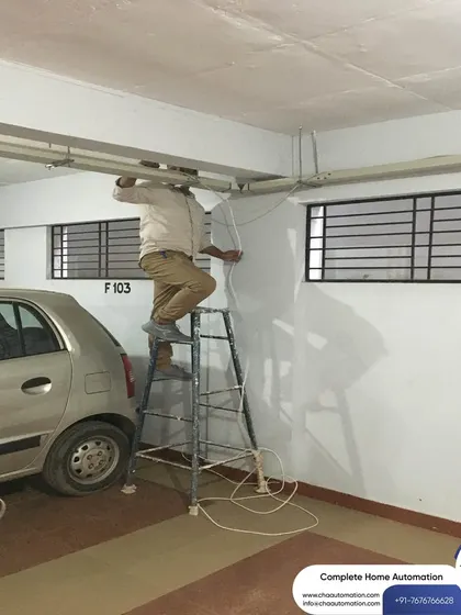 Here, our installer is running wires along the ceiling conduit in a parking area. This meticulous approach to wiring ensures the system is both reliable and aesthetically pleasing.