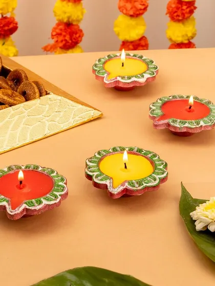 Colorful and playful decorative candles from Gopal Shoppe. The styling with marigold garlands adds an authentic, festive touch.