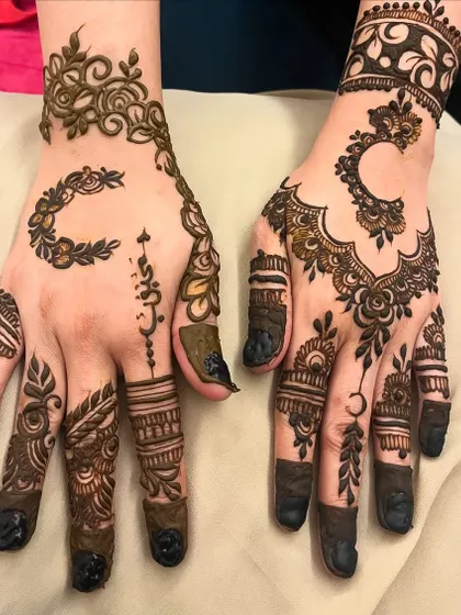 This design shows a mix of modern elements, including a crescent moon, Arabic-style lettering, and bold fingertips.