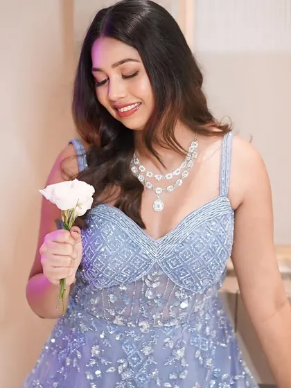 A sweet moment with a white rose. Her lavender gown and soft makeup create a look of pure romance.
