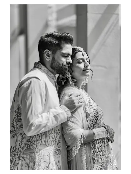 A tender, black and white portrait of the couple. The soft lighting and their gentle embrace create a classic and romantic image.