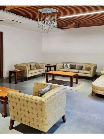 A formal living room with classic furniture and a modern wooden rafter ceiling.