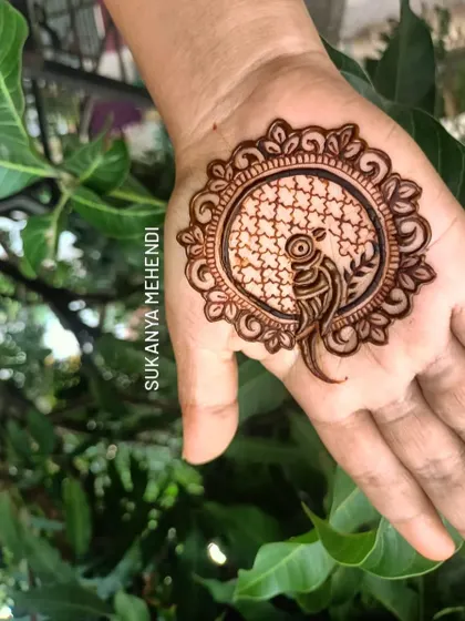 A beautiful mandala design featuring a peacock inside. This style is perfect for someone who wants a single, impactful motif on their palm.