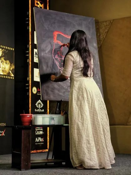 A side view of the live painting in action. You can see the stage setup and how I work with my easel and paints to create a large-scale piece for the audience.