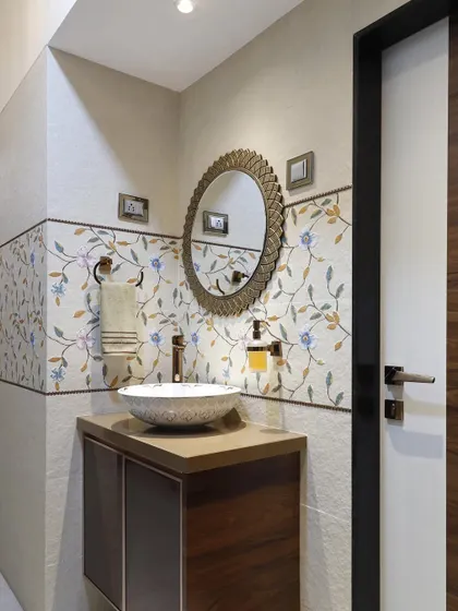 A wider view of the wash area, showing the decorative mirror and the floral tile band. This space, though compact, is designed with a high level of detail and artistry.