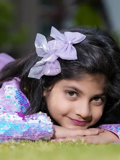 We capture beautiful portraits for kids of all ages. This lovely girl is enjoying a quiet moment, lying on the grass in our garden.