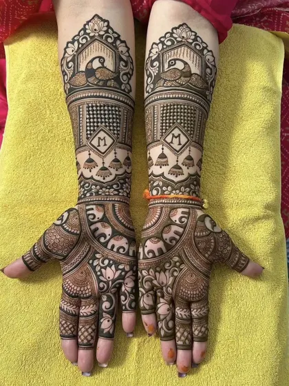 A classic bridal design featuring majestic peacocks at the wrist and personalized initial 'M' on the palm. The pattern combines animal motifs with traditional jhumka (earring) designs.