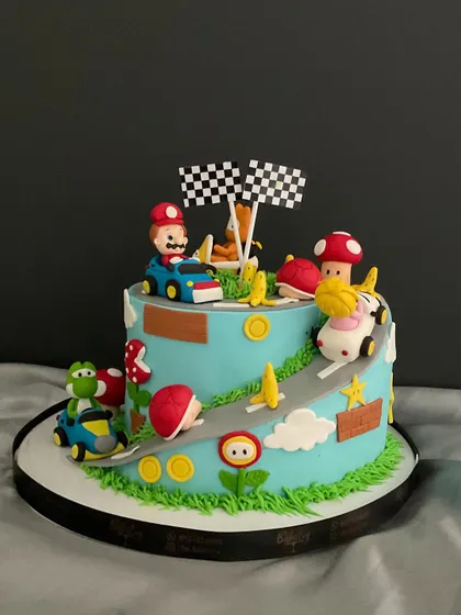 Let's-a-go! This Mario Kart-themed cake brings the race to the party, with Mario and Yoshi in their karts speeding along a track dotted with coins and mushrooms.